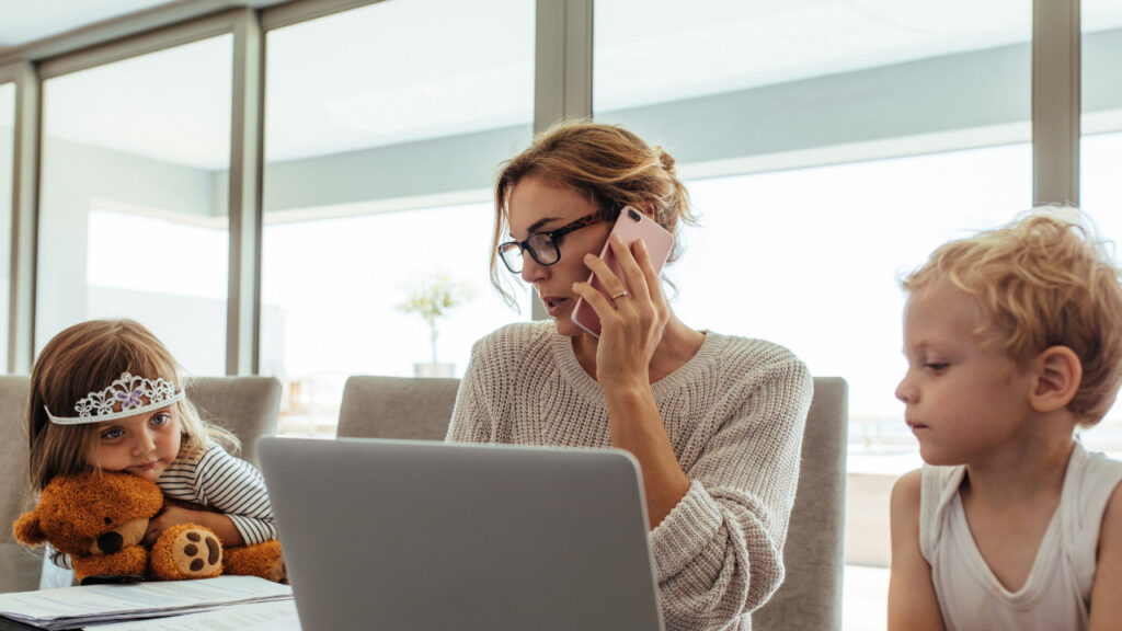 woman working at home from table with children.